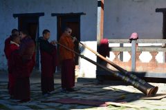 Mönche blasen Gyaling-Trompeten in einem Kloster in Bhutan.